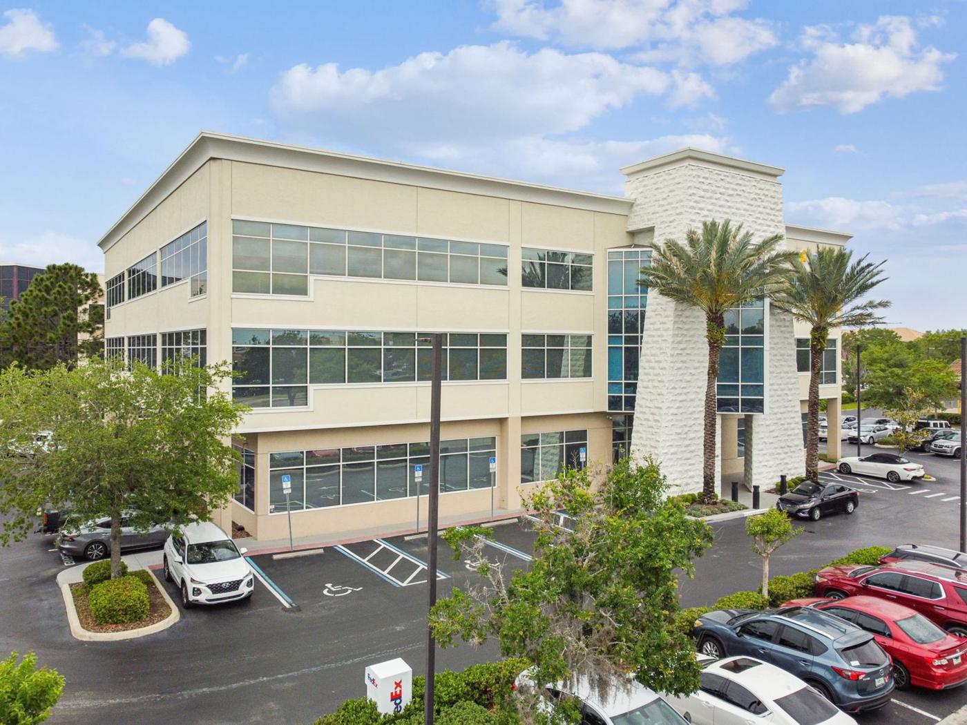 Aerial view of 1540 International Parkway, a three-story office building with palm-lined entry and surface parking