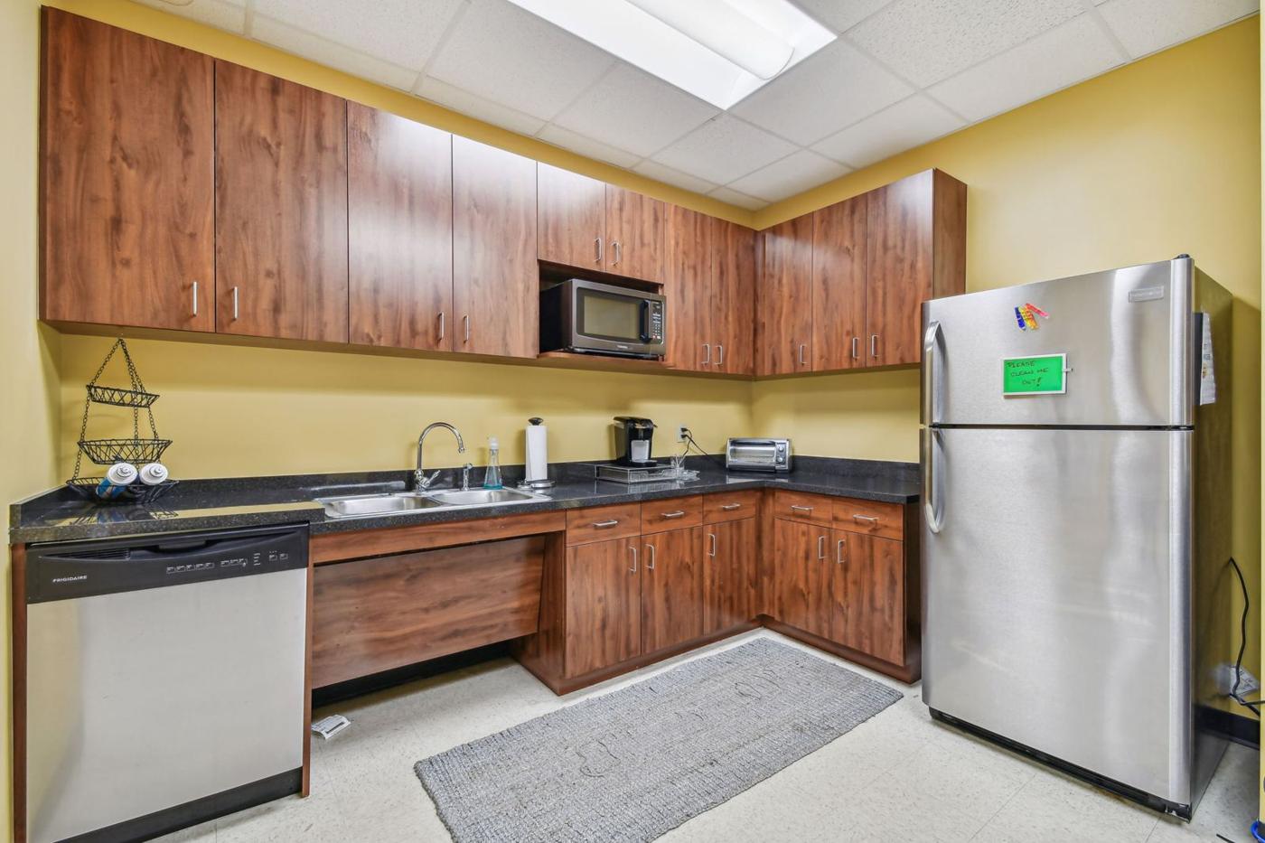 Suite 3050: kitchen with wood cabinets, microwave, sink and refrigerator
